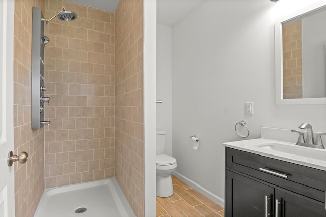 bathroom featuring tiled shower, vanity, and toilet