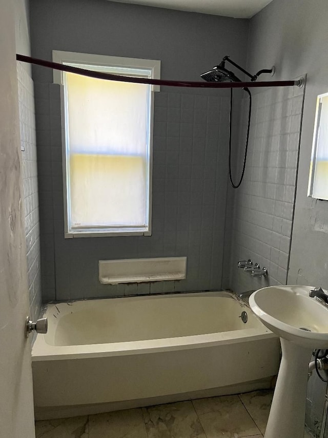 bathroom with tiled shower / bath combo and a healthy amount of sunlight