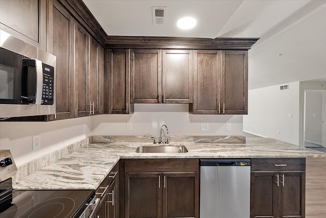 kitchen featuring appliances with stainless steel finishes, dark brown cabinets, and sink