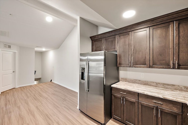 kitchen with light stone counters, dark brown cabinets, light hardwood / wood-style floors, and stainless steel refrigerator with ice dispenser