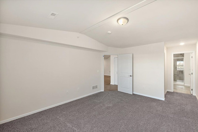 unfurnished bedroom with dark colored carpet and vaulted ceiling