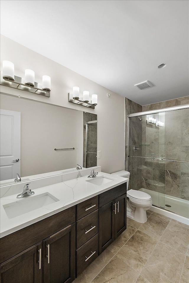 bathroom with vanity, toilet, and an enclosed shower