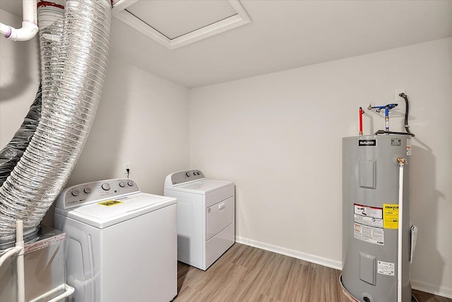 washroom featuring electric water heater, light hardwood / wood-style flooring, and washing machine and dryer