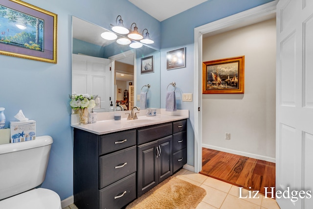 bathroom featuring vanity, wood-type flooring, and toilet