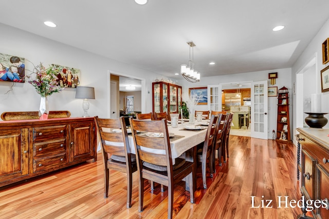 dining room featuring french doors, light hardwood / wood-style flooring, and a notable chandelier