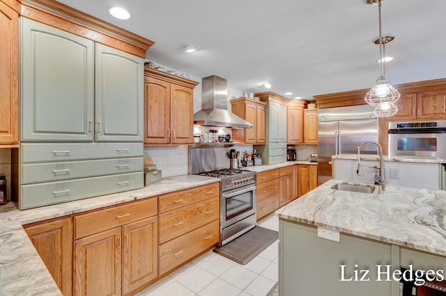 kitchen featuring pendant lighting, high quality appliances, backsplash, sink, and wall chimney exhaust hood