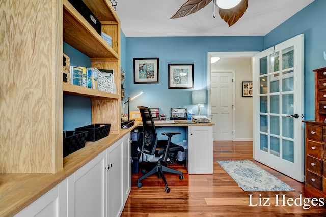 office area featuring ceiling fan, built in desk, and light wood-type flooring