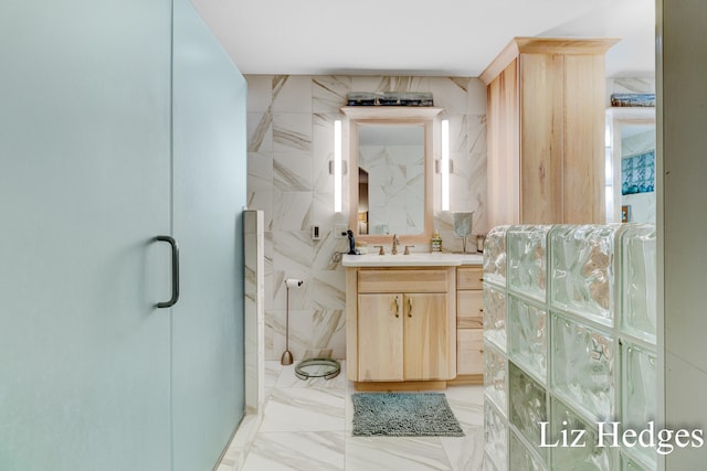 bathroom featuring vanity, an enclosed shower, and tile walls