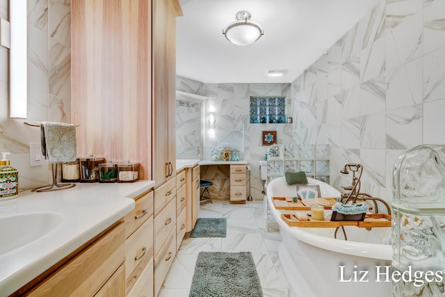 bathroom with a tub to relax in, vanity, and tile walls