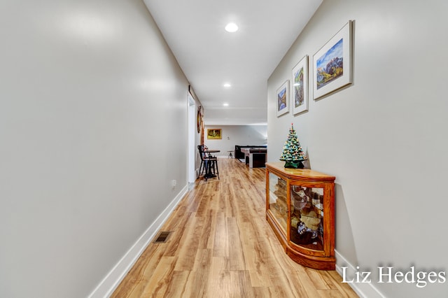 corridor with light hardwood / wood-style floors