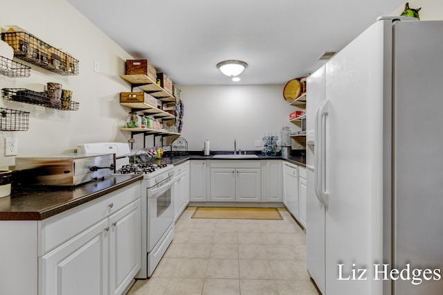 kitchen featuring white cabinets, white appliances, sink, and light tile patterned floors