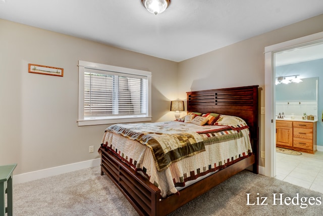 carpeted bedroom with sink and ensuite bath