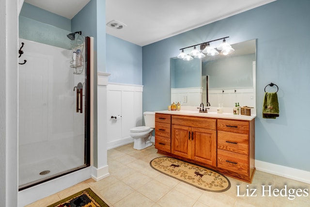 bathroom featuring tile patterned flooring, vanity, a shower with shower door, and toilet