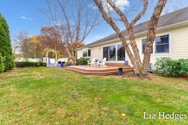 rear view of property featuring a yard and a deck