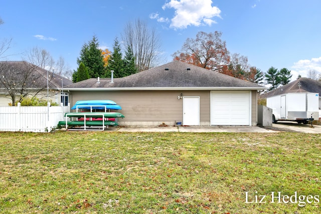 rear view of house featuring a yard and a garage