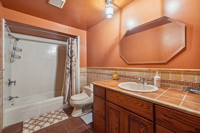 full bathroom with shower / tub combo, vanity, tile walls, tile patterned flooring, and toilet