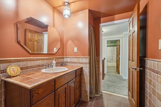 bathroom with tile patterned floors, vanity, and tile walls