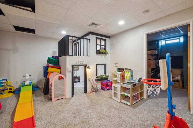 playroom with carpet floors and a paneled ceiling