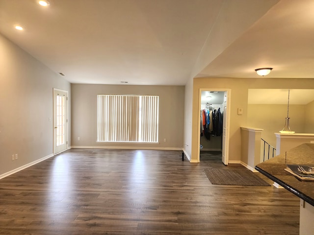 unfurnished living room with dark wood-type flooring and lofted ceiling