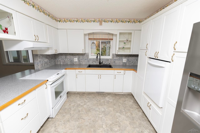 kitchen featuring white range with electric cooktop, white cabinetry, sink, and stainless steel refrigerator