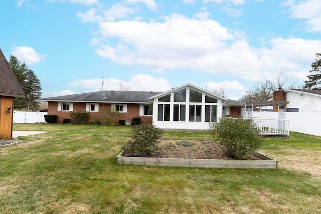 back of property featuring a sunroom and a yard