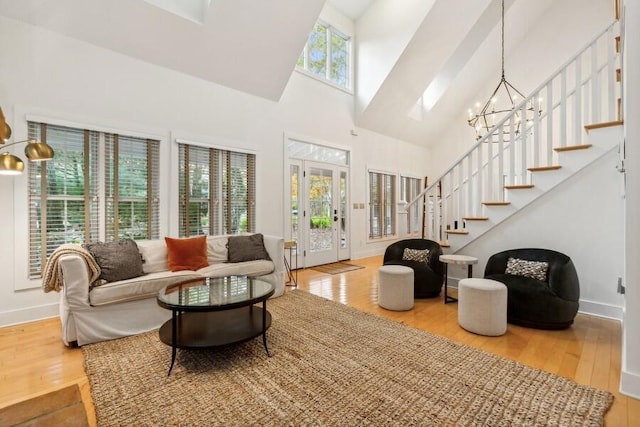 living room with plenty of natural light, wood-type flooring, and high vaulted ceiling