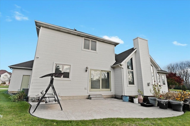 rear view of property featuring a patio area and a lawn