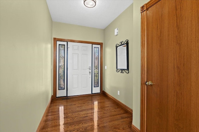 foyer entrance featuring a textured ceiling and dark hardwood / wood-style floors