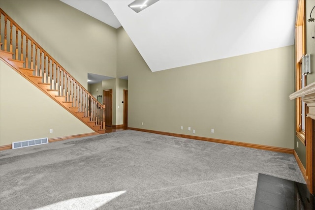 unfurnished living room featuring carpet flooring and high vaulted ceiling