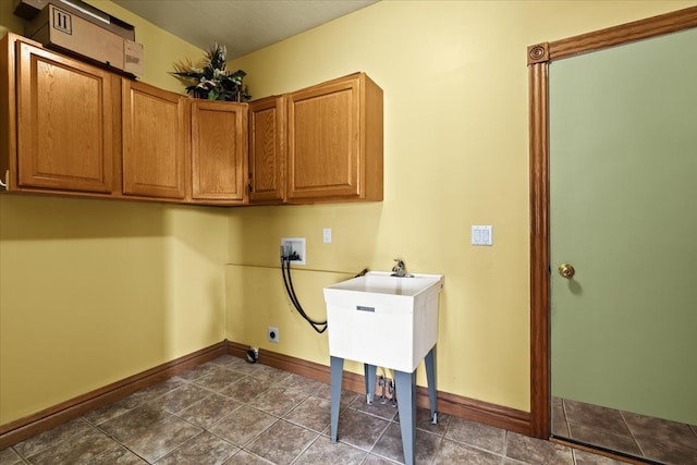 clothes washing area featuring washer hookup, cabinets, and dark tile patterned floors