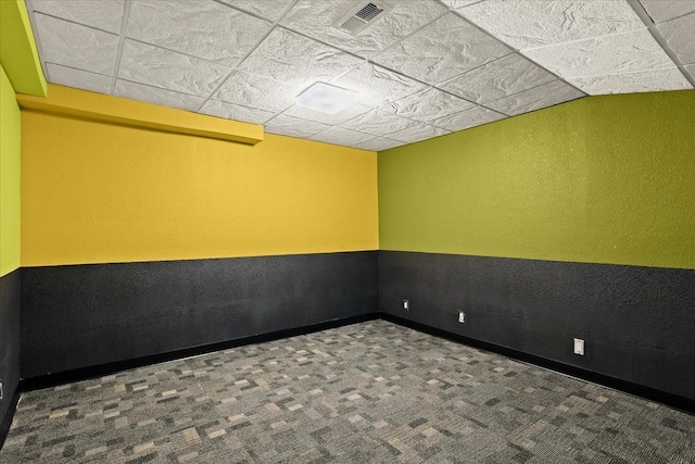 unfurnished room featuring carpet flooring and a drop ceiling