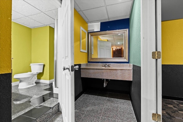 bathroom featuring a paneled ceiling and toilet