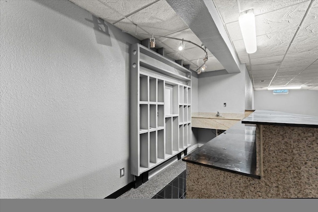 kitchen with a paneled ceiling and rail lighting