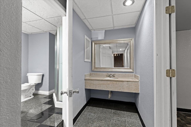 bathroom featuring sink, a paneled ceiling, and toilet