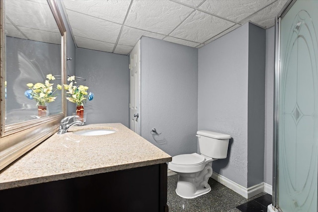 bathroom with a paneled ceiling, vanity, and toilet