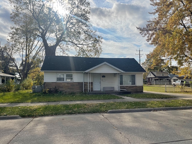 bungalow-style house featuring cooling unit and a front yard