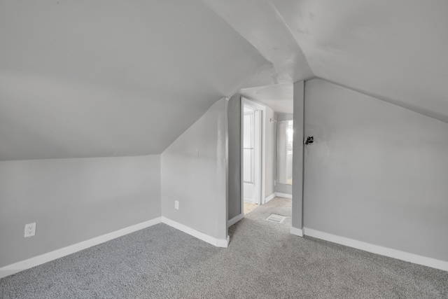 bonus room featuring light colored carpet and vaulted ceiling