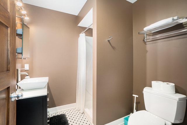 bathroom with vanity, toilet, and curtained shower