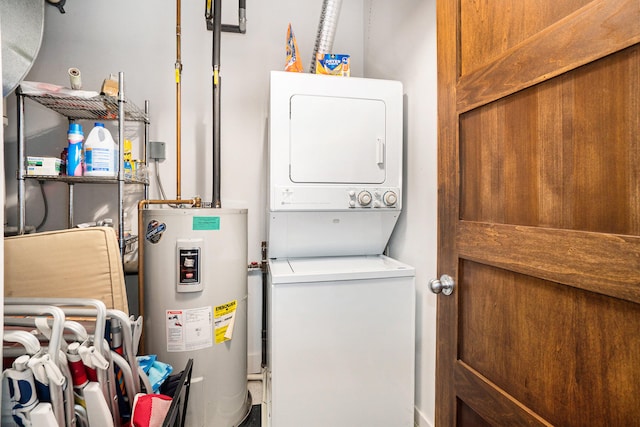 clothes washing area featuring electric water heater and stacked washer / dryer