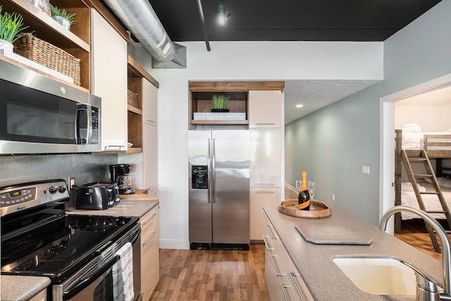 kitchen featuring dark hardwood / wood-style flooring, stainless steel appliances, white cabinetry, and sink