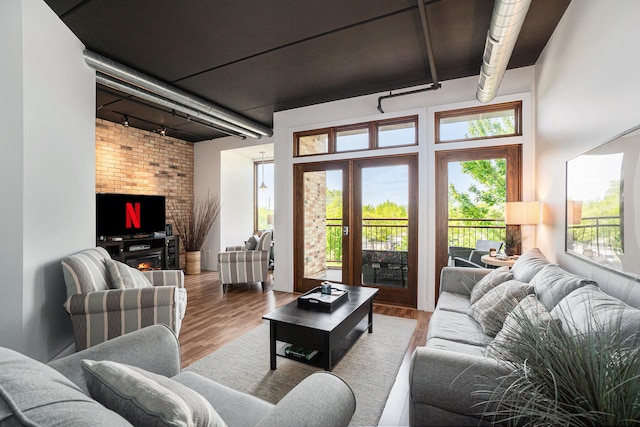 living room with a fireplace, rail lighting, and wood-type flooring