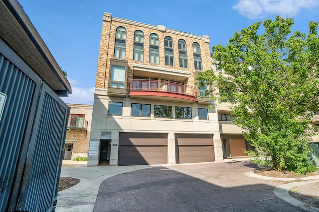 view of property with a balcony and a garage