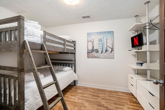 bedroom featuring a textured ceiling and light wood-type flooring