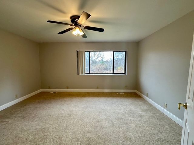 carpeted empty room with ceiling fan