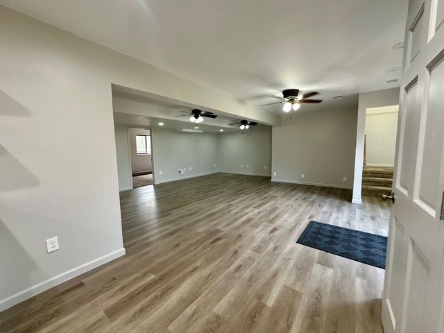 unfurnished living room with ceiling fan and light wood-type flooring