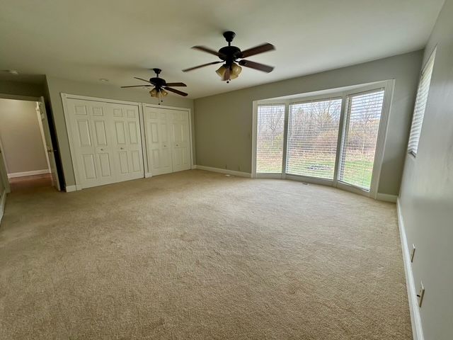 unfurnished bedroom with ceiling fan and light carpet