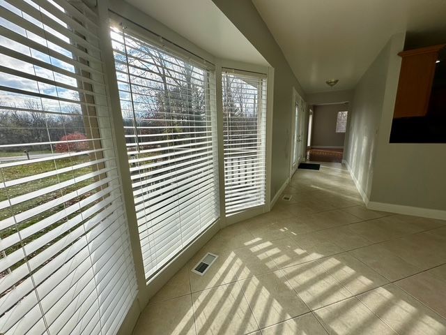 hall featuring a wealth of natural light and light tile patterned floors