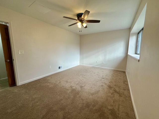 carpeted spare room with ceiling fan