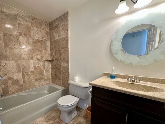 full bathroom with vanity, toilet, and tiled shower / bath combo