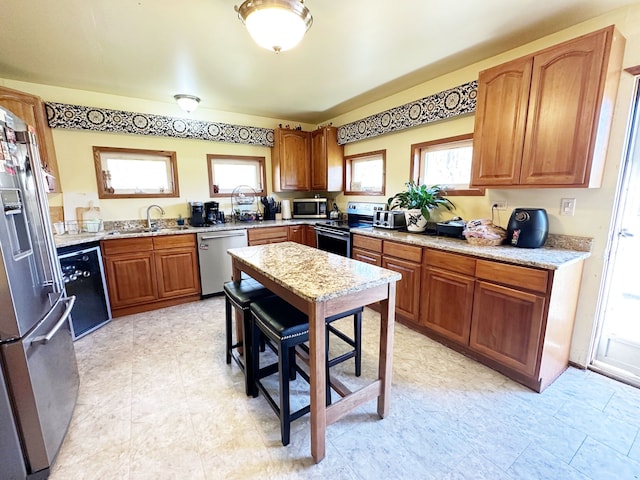 kitchen with light stone counters, sink, and stainless steel appliances